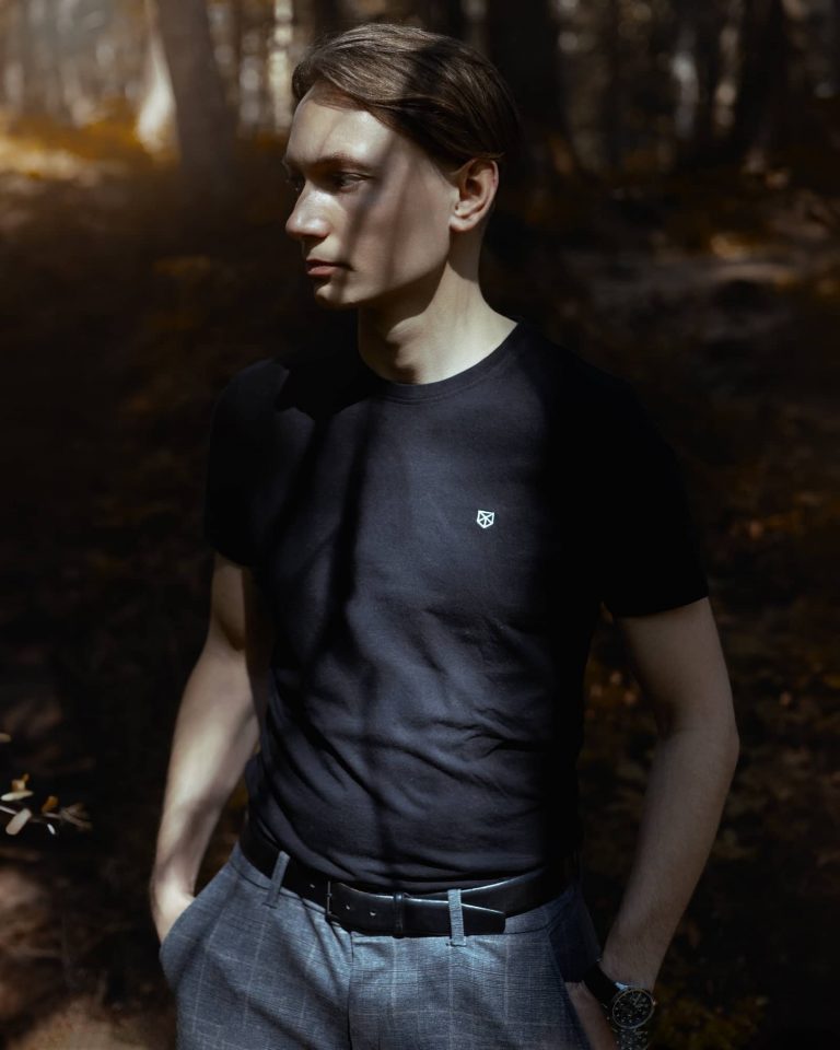 Portrait eines jungen Mannes im Wald der Schatten im Gesicht hat