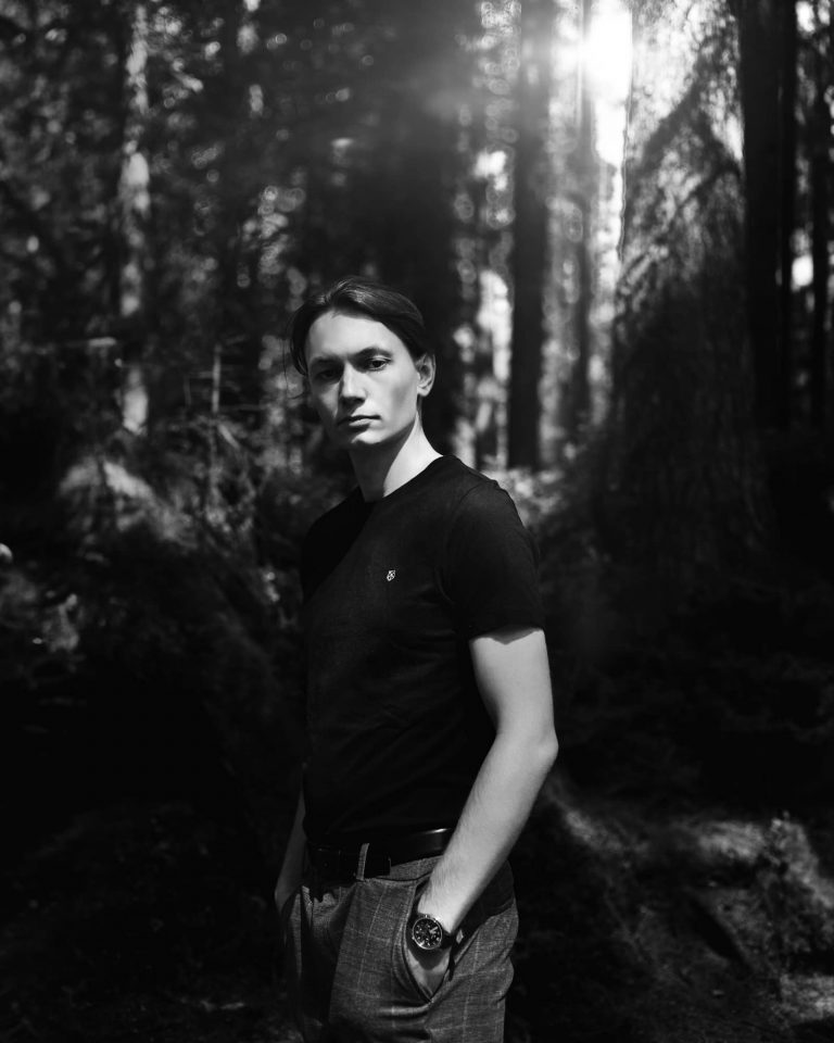 Schwarz-Weißes Portrait von einem jungen Mann im Wald